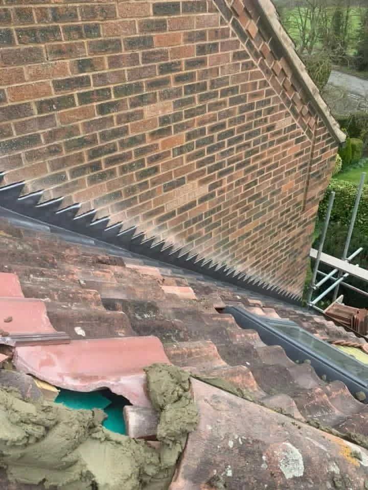 Roof-to-brick-wall junction with exposed materials during flashing work