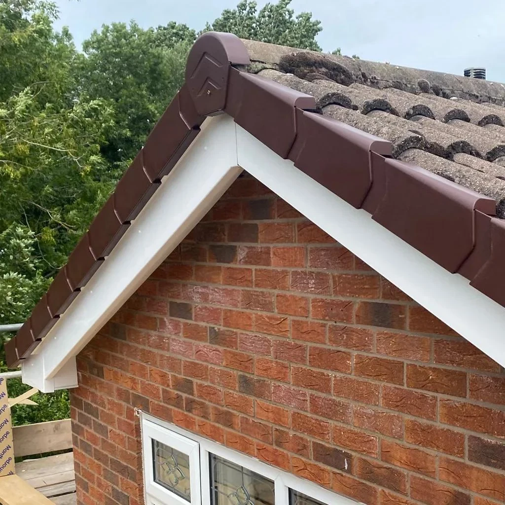 Brown dry verge caps and white roofline boards on a brick gable